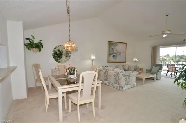 a dining room with furniture a chandelier and window