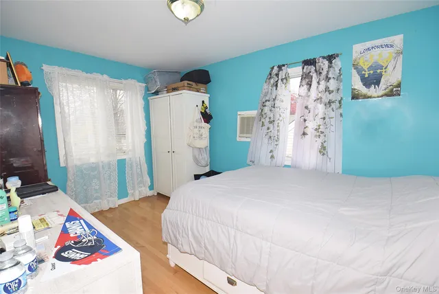 a living room with a bed furniture chandelier and a window