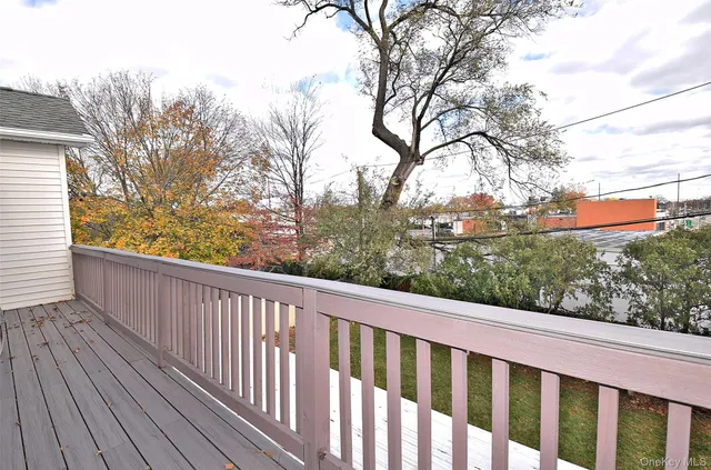 a view of a wooden balcony and trees