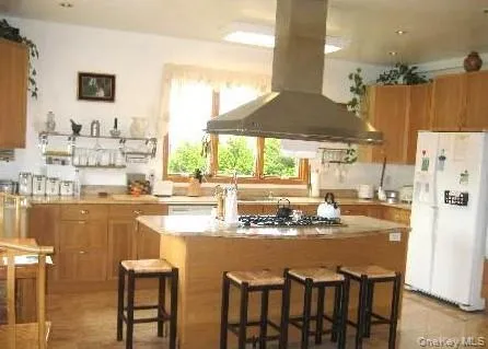 a kitchen with stainless steel appliances kitchen island granite countertop a table and chairs