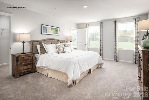 a spacious bedroom with a bed and a lamp