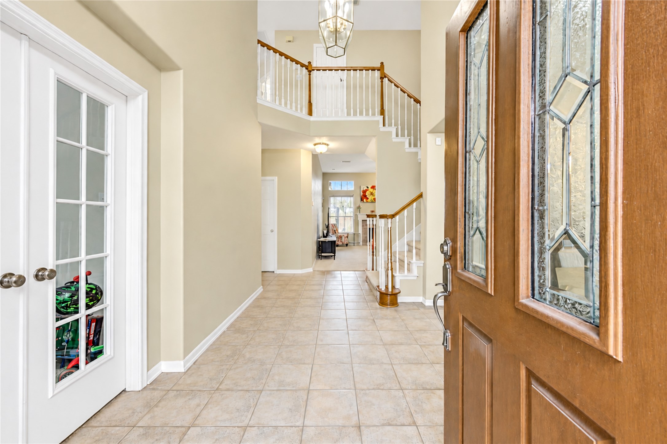 12806 Ridge Bank Lane Houston, TX 77041 - Photo 3 of 44 Stunning entryway with elegant tile flooring and a grand staircase leading to the second floor, enhanced by natural light and a welcoming ambiance.