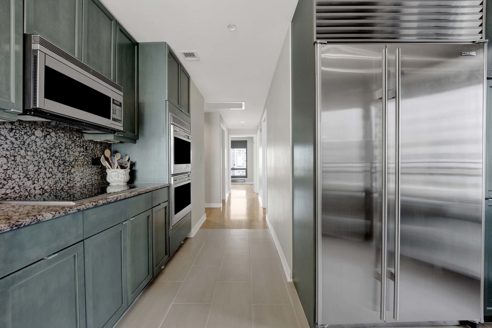 130 North Garland Court, Unit 3001 Chicago, IL 60602 - Photo 21 of 63 a kitchen with stainless steel appliances kitchen island granite countertop a refrigerator and a stove