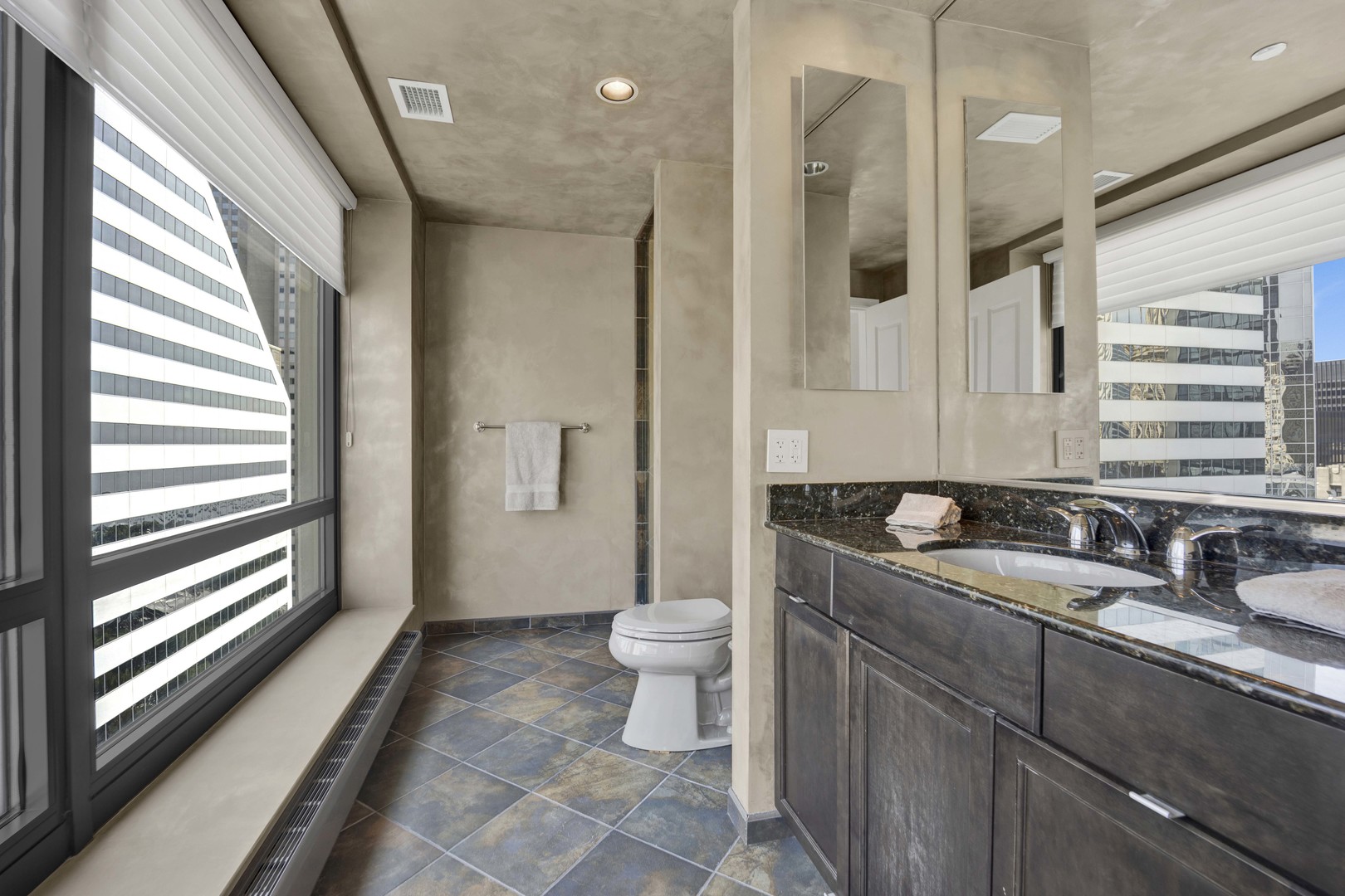 130 North Garland Court, Unit 3001 Chicago, IL 60602 - Photo 30 of 63 a bathroom with a sink a toilet a large mirror and shower