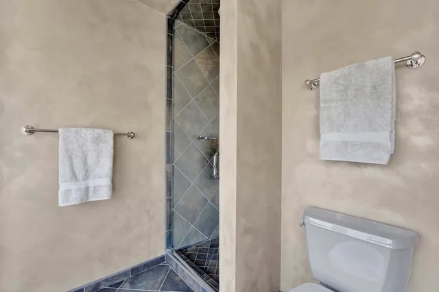 a bathroom with a granite countertop sink toilet a mirror and shower