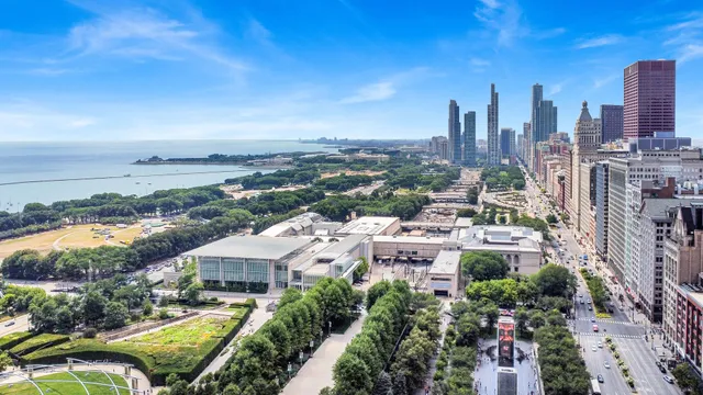 an aerial view of a multi story building with a yard and large trees