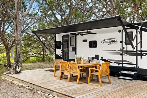 a living room with furniture a flat screen tv and a large window