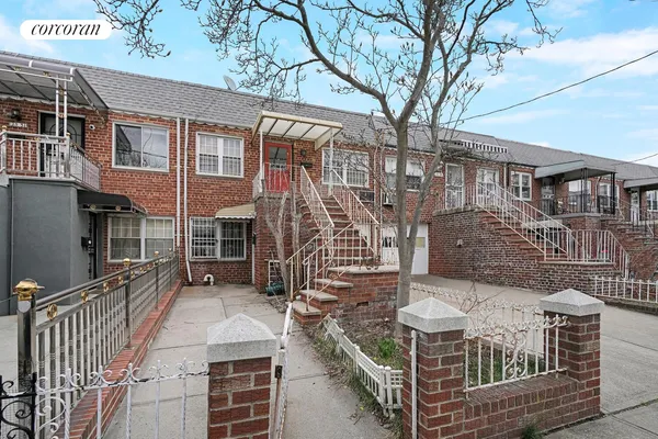 a view of buildings with a small yard and wooden fence