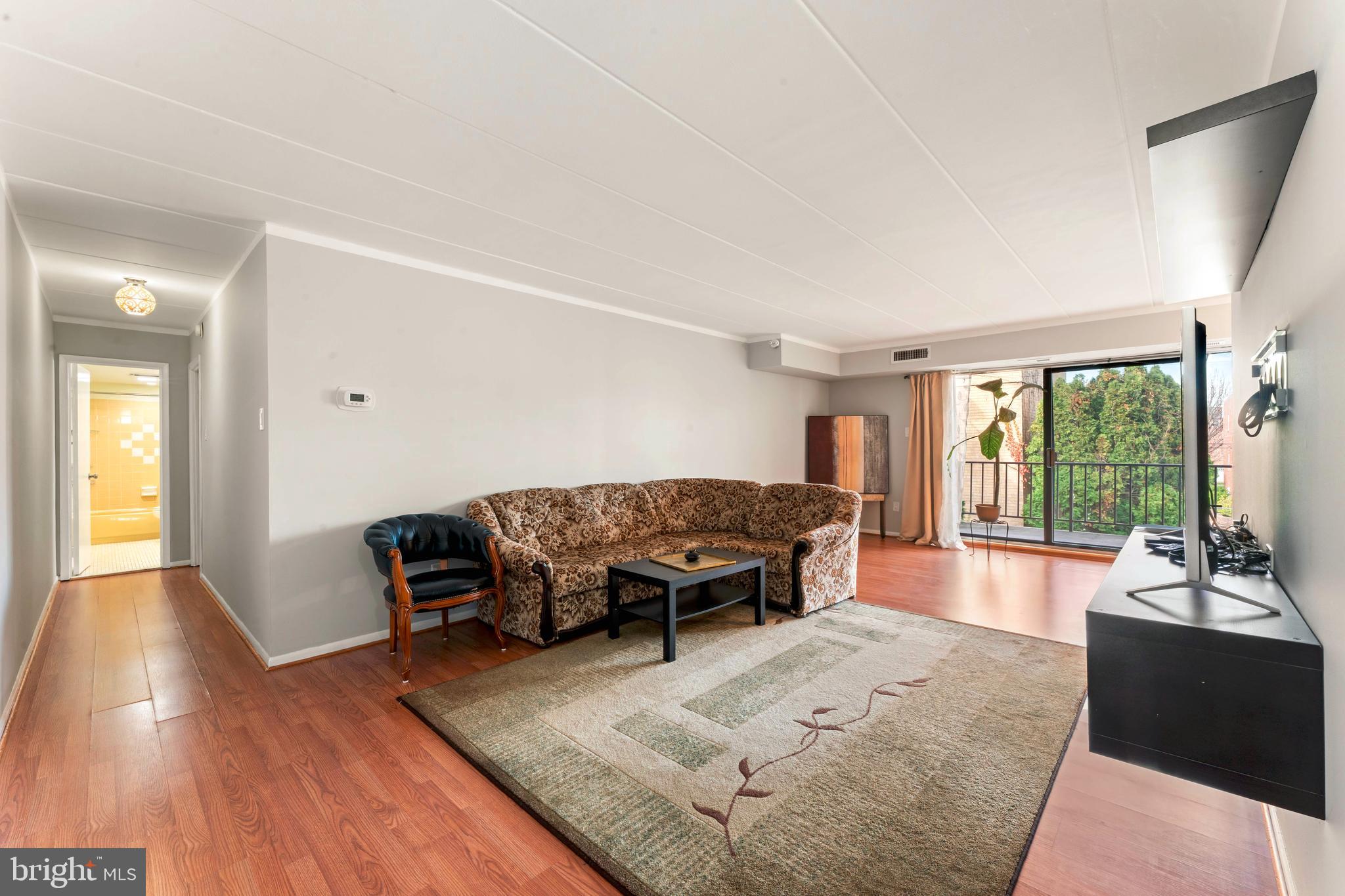 8940 Krewstown Road, Unit 204 Philadelphia, PA 19115 - Photo 6 of 23 a living room with furniture and a large window