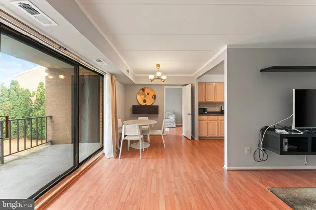 a view of a living room filled with furniture and wooden floor
