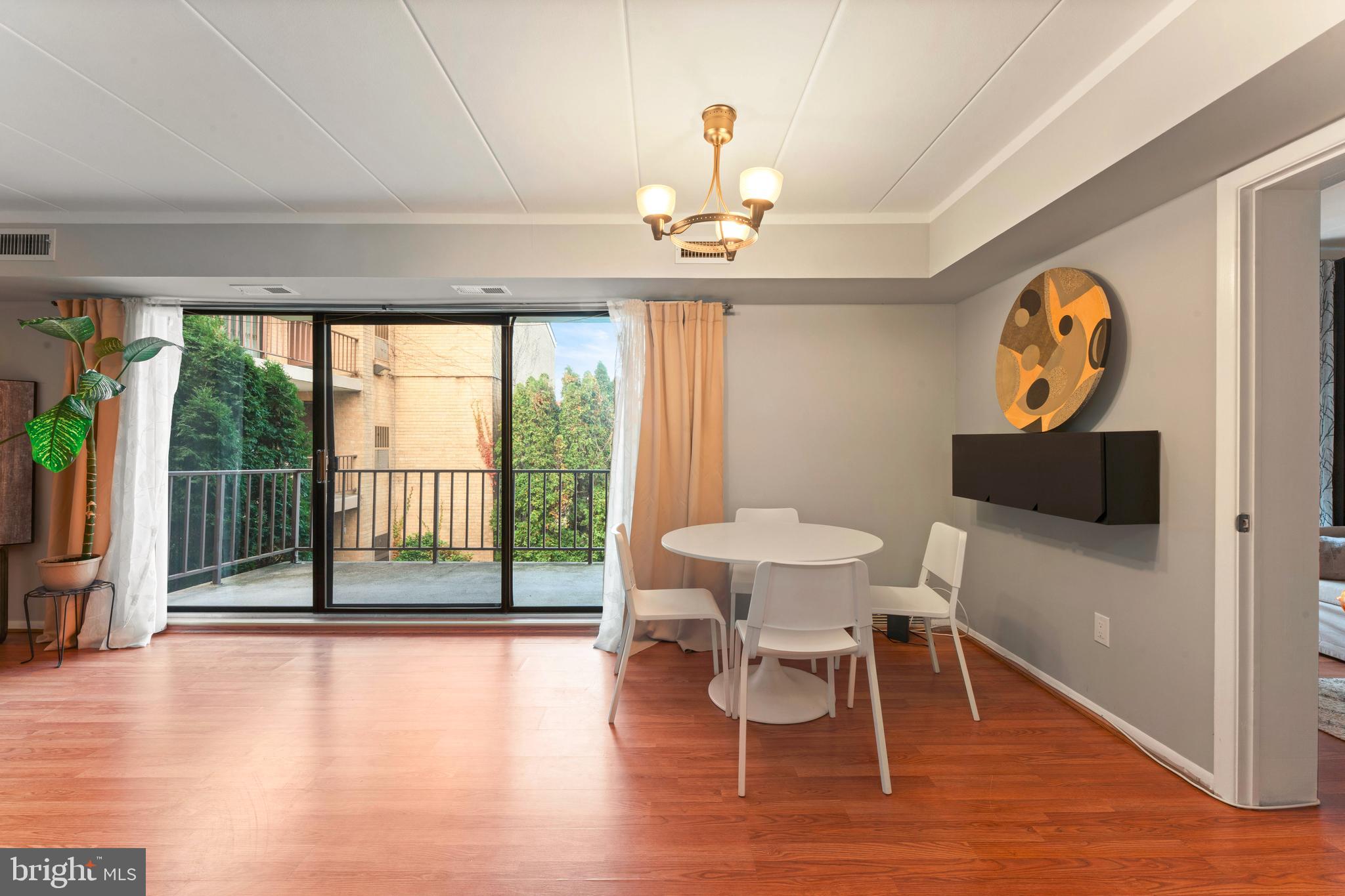 8940 Krewstown Road, Unit 204 Philadelphia, PA 19115 - Photo 9 of 23 a view of a dining room with furniture a chandelier and wooden floor