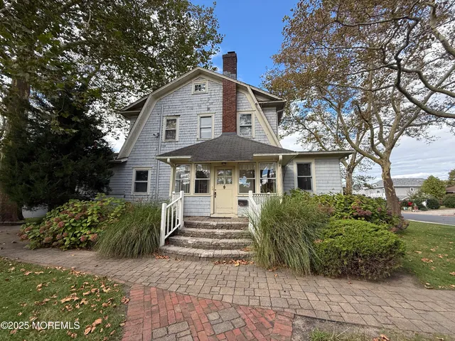 a front view of a house with yard and green space