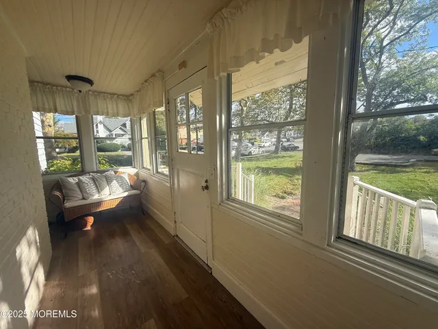 a view of a large room with wooden floor and windows