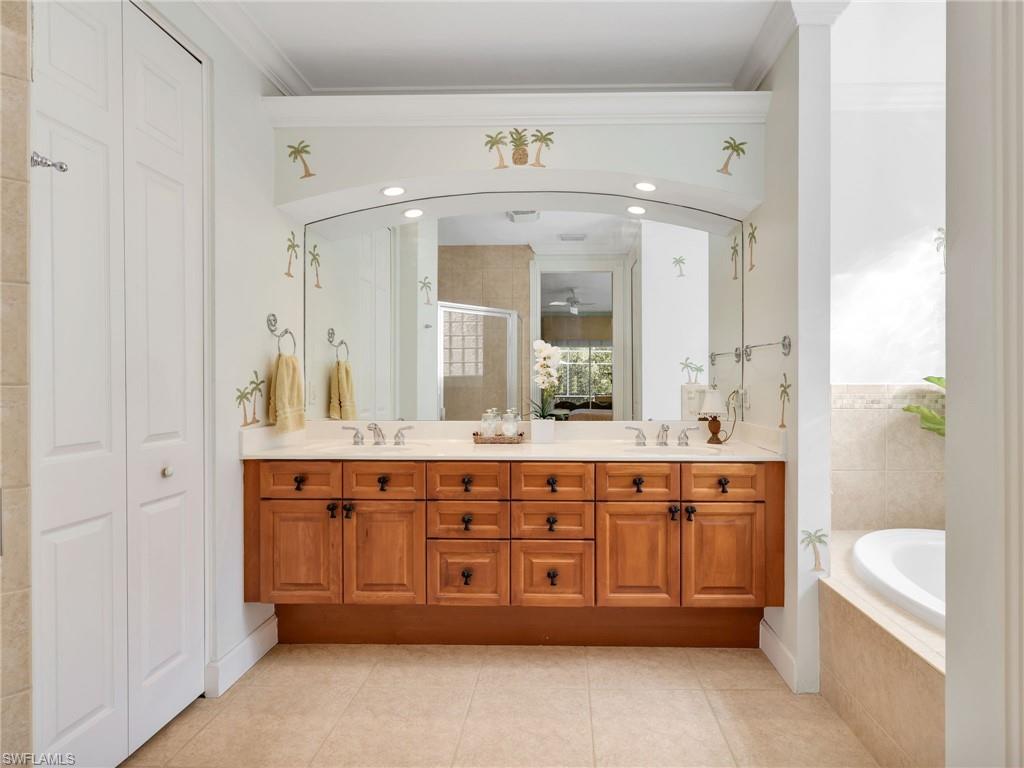 353 Steerforth Court Naples, FL 34110 - Photo 20 of 40 a spacious bathroom with a granite countertop sink and a mirror
