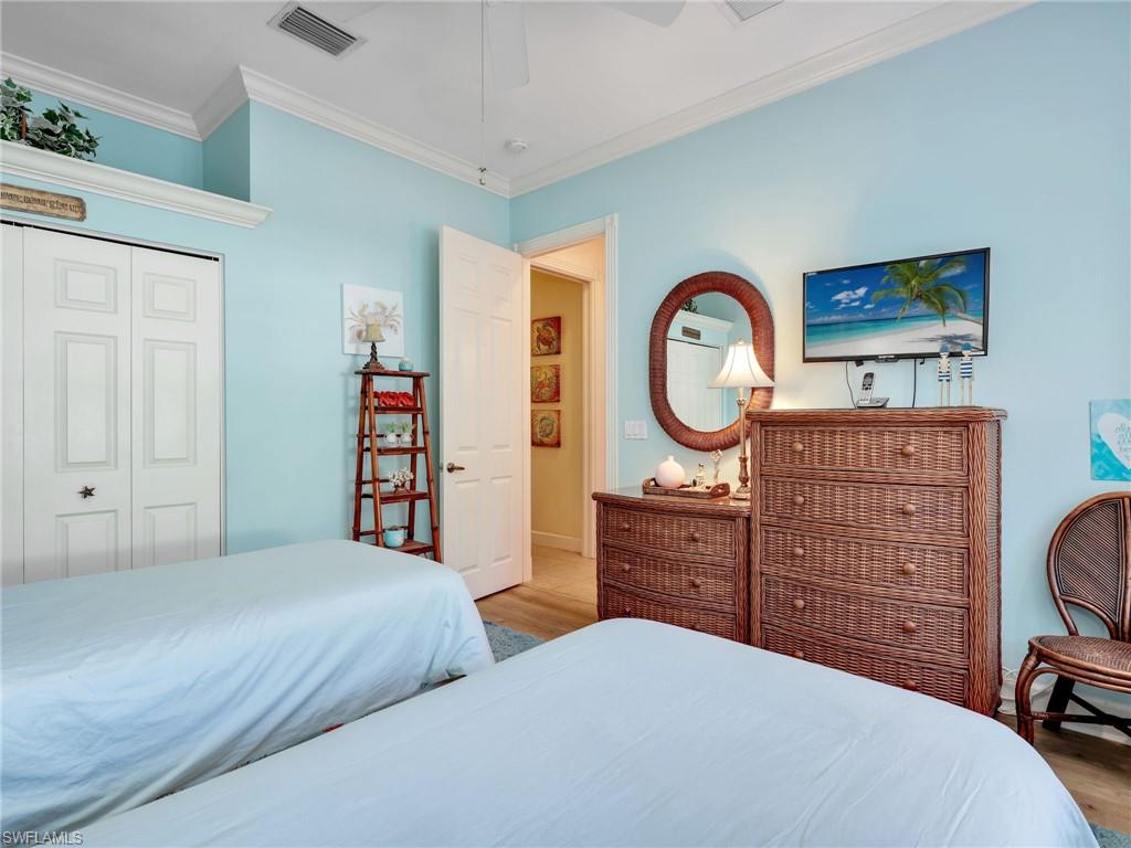 353 Steerforth Court Naples, FL 34110 - Photo 26 of 40 a bedroom with a bed and a dresser