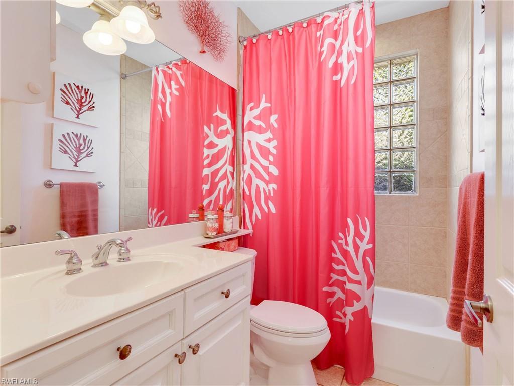353 Steerforth Court Naples, FL 34110 - Photo 27 of 40 a bathroom with a sink a toilet and shower curtain