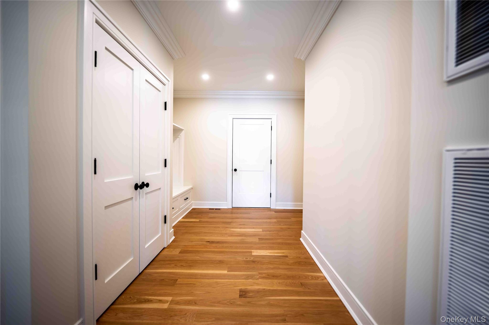 106 Cove Road Asharoken, NY 11768 - Photo 16 of 46 Hall featuring light wood-style floors, a heating unit, ornamental molding, and recessed lighting
