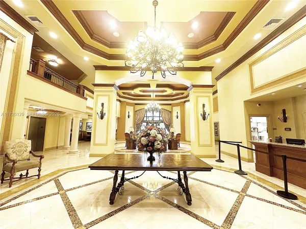 a lobby with furniture and a chandelier