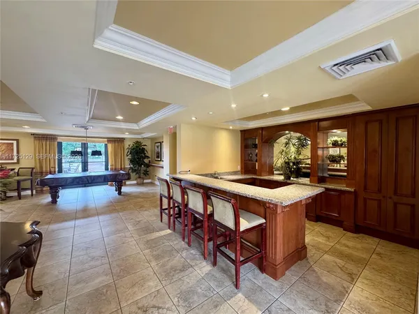 a kitchen with stainless steel appliances granite countertop table chairs sink and cabinets