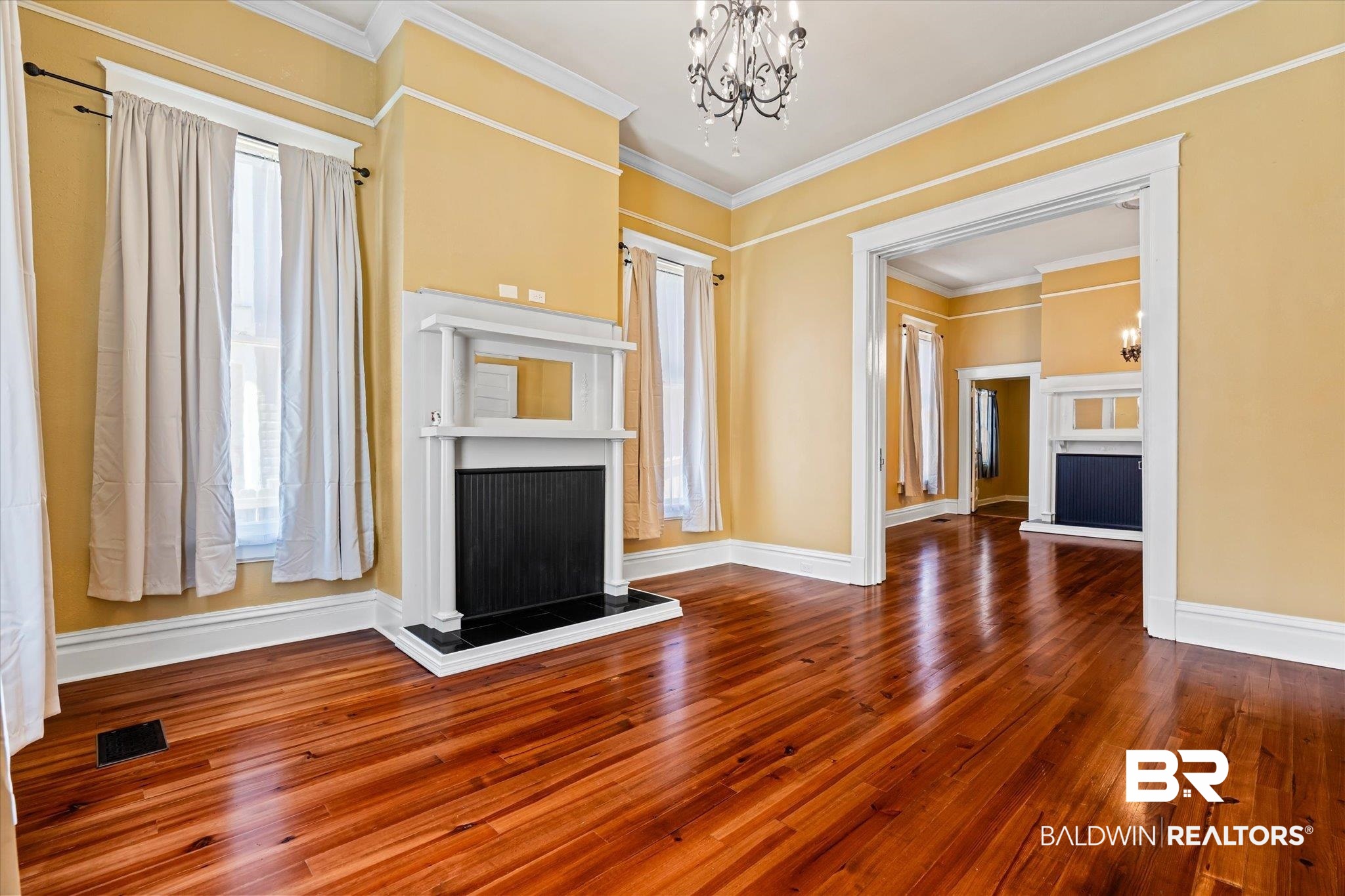 1310 Brown Street Mobile, AL 36604 - Photo 4 of 18 Unfurnished living room featuring crown molding, wood-type flooring, a wealth of natural light, and a chandelier