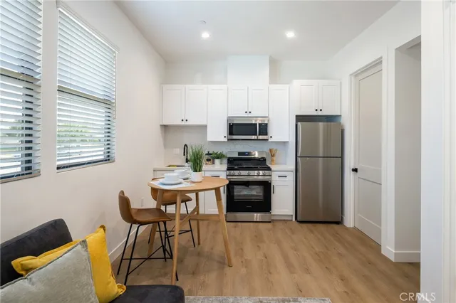 a kitchen with stainless steel appliances a stove a sink refrigerator and a microwave