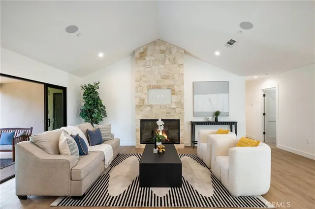 a living room with furniture a fireplace and a chandelier
