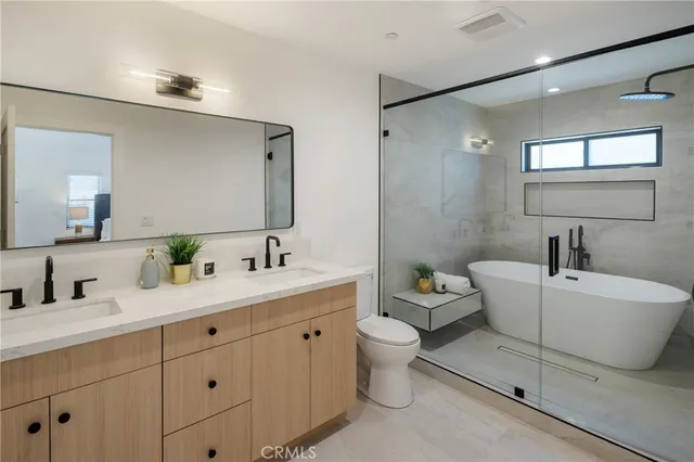 a spacious bathroom with a double vanity sink a mirror and a bathtub