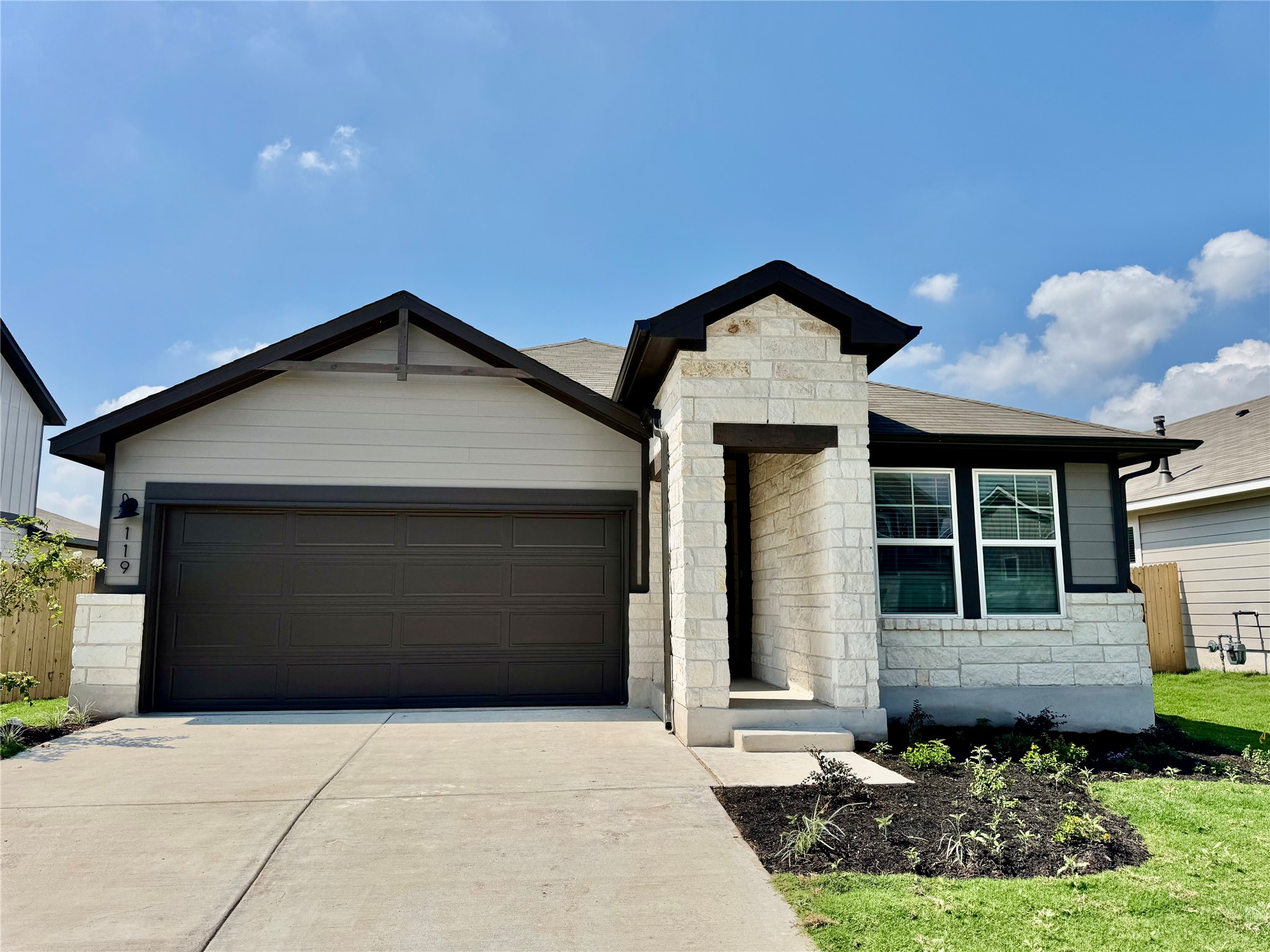 119 Boondoggle Ridge Cedar Creek, TX 78612 - Photo 1 of 1 View of front of property with an attached garage, stone siding, and concrete driveway