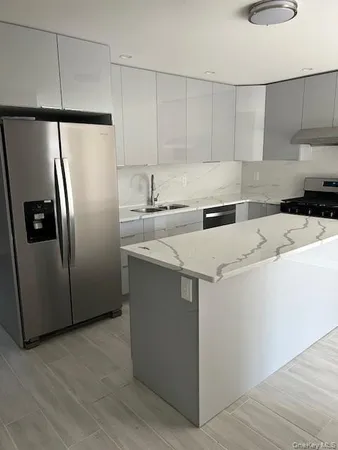 a kitchen with a refrigerator sink and cabinets