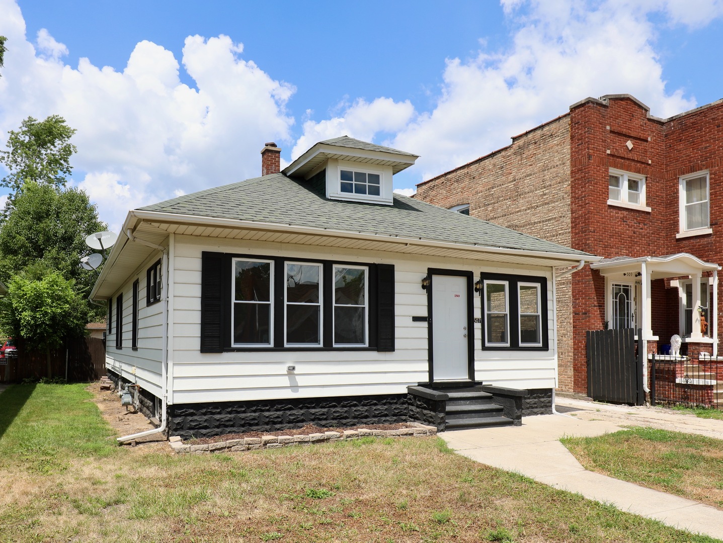 507 Grant Avenue Joliet, IL 60433 - Photo 1 of 16 a front view of a house with a garden