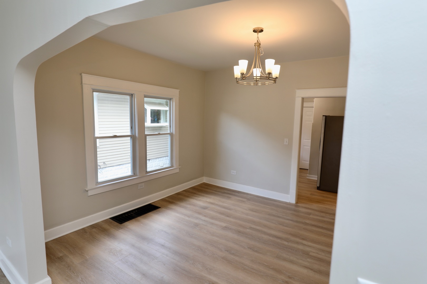 507 Grant Avenue Joliet, IL 60433 - Photo 7 of 16 an empty room with wooden floor chandelier and windows
