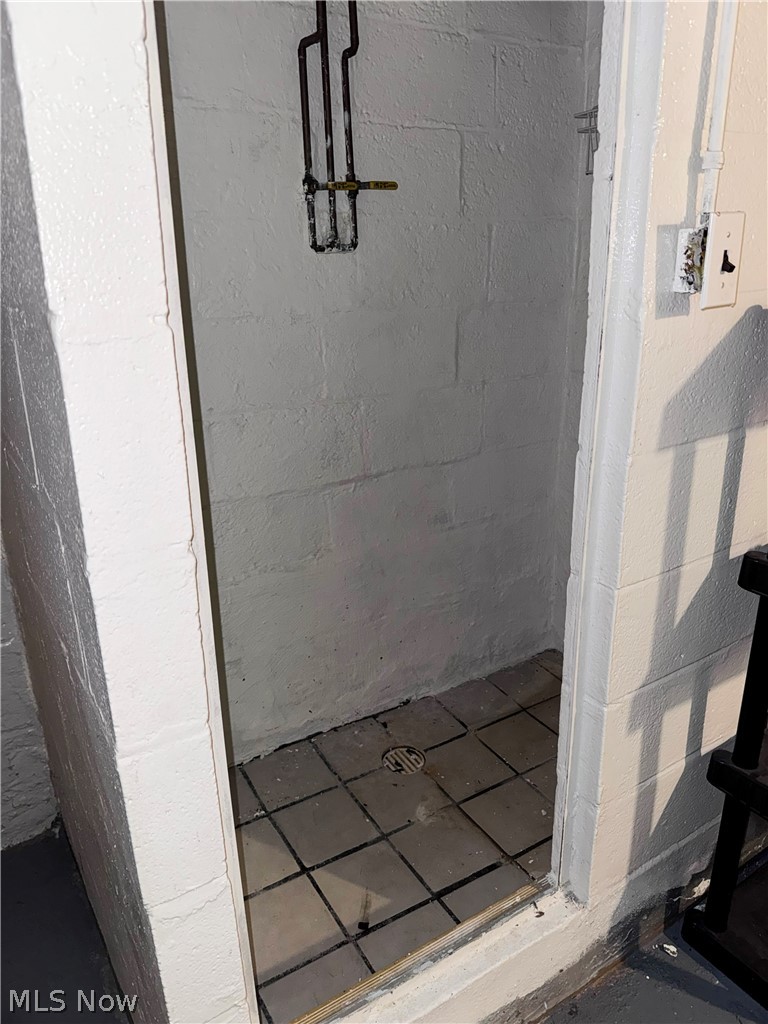 7121 North Lima Road Youngstown, OH 44514 - Photo 35 of 37 Shower stall featuring painted cinder block walls and a tiled floor with a central drain