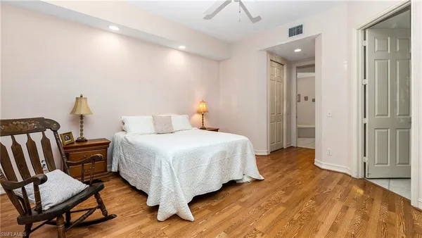 a bedroom with a bed a chair and the dresser