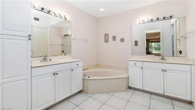 a bathroom with a tub sink shower and mirror