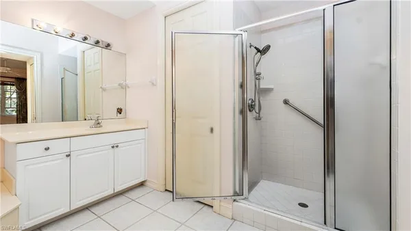 a spacious bathroom with a shower sink and mirror