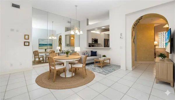 a living room with couches a table and a chandelier