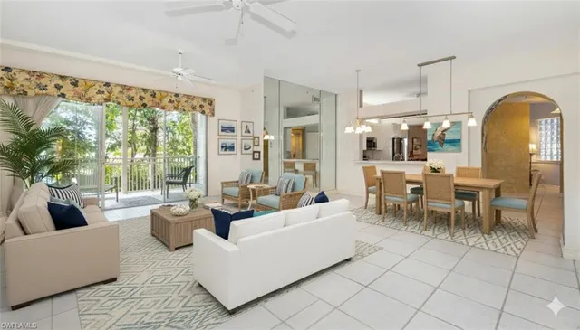 a living room with furniture potted plant and a large window