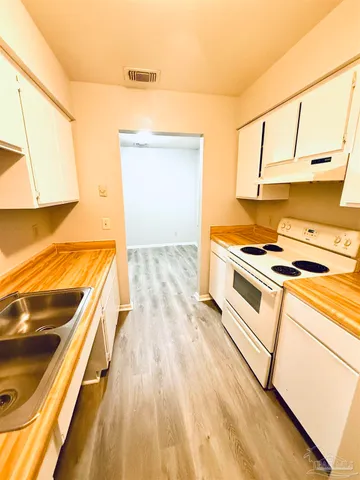 a view of a kitchen with wooden floor and a sink