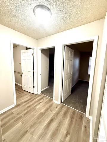 a view of a room with wooden floor and white walls