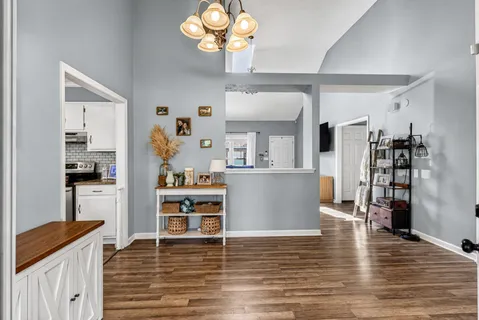 a living room with hard wood floors and a view of kitchen