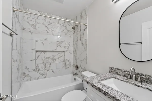 a bathroom with a granite countertop sink toilet and shower