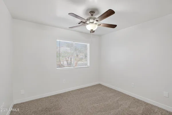 an empty room with window and fan