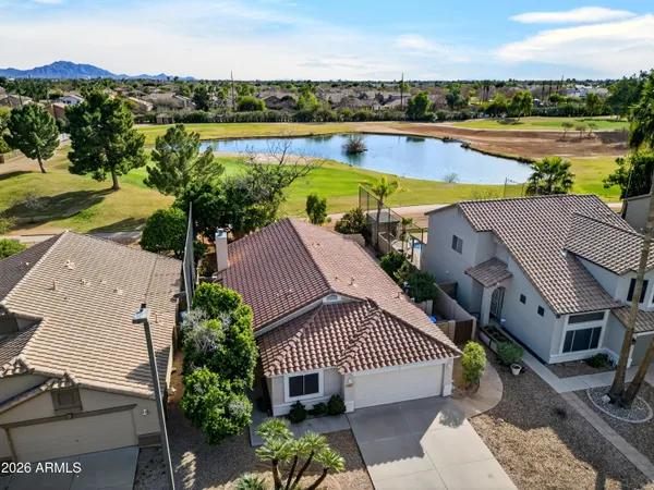 an aerial view of a house with a garden and lake view