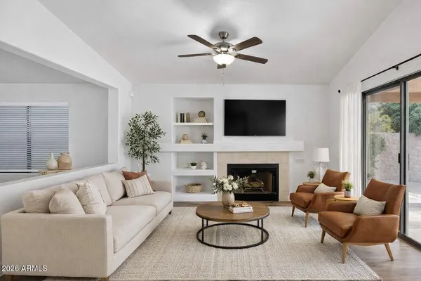 a living room with furniture a fireplace and a flat screen tv
