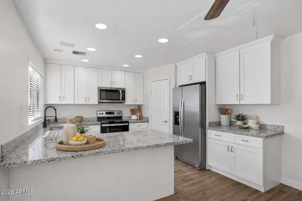a kitchen with a sink stainless steel appliances and white cabinets