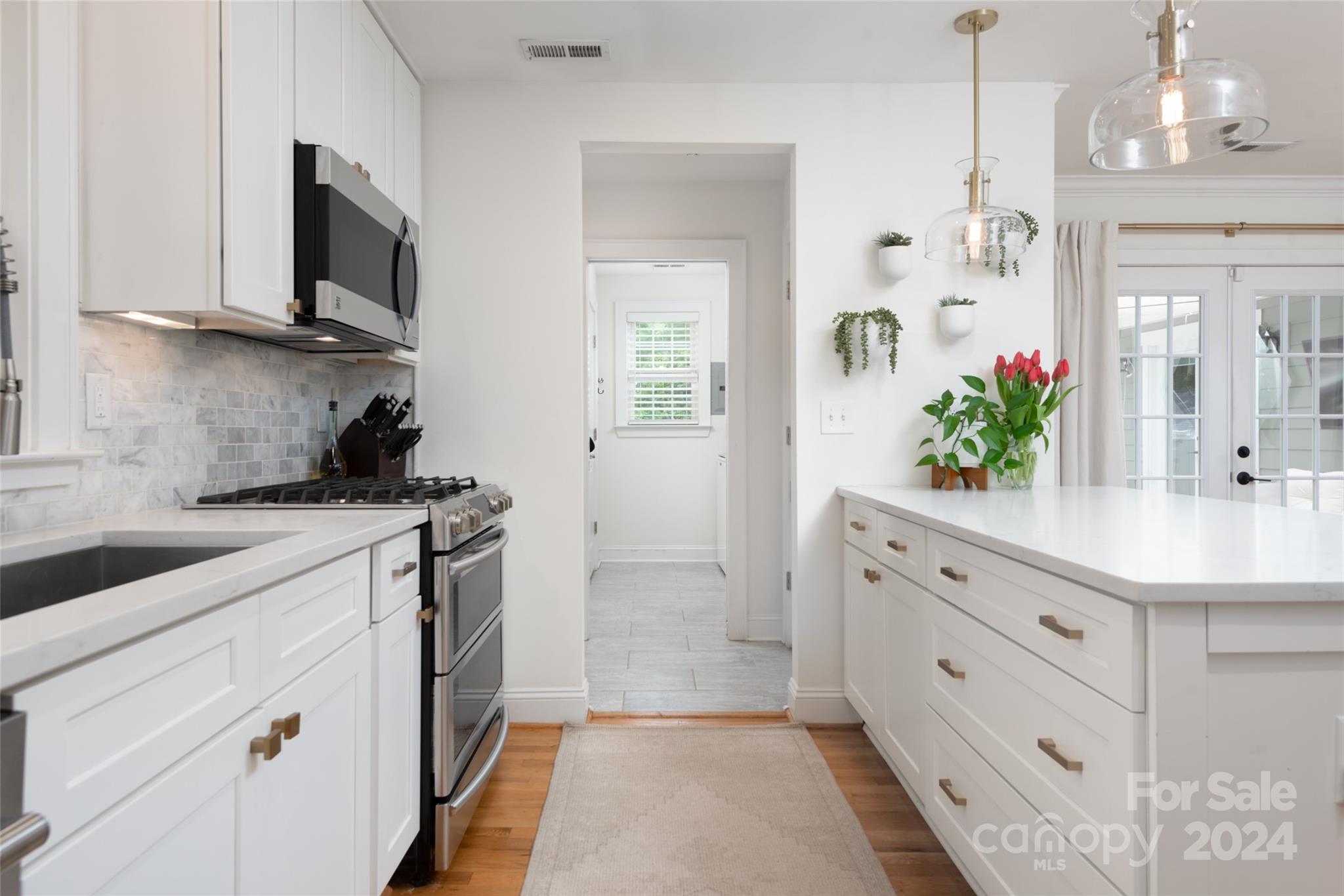 665 Marsh Road Charlotte, NC 28209 - Photo 12 of 31 a kitchen with cabinets stainless steel appliances a sink and a potted plant