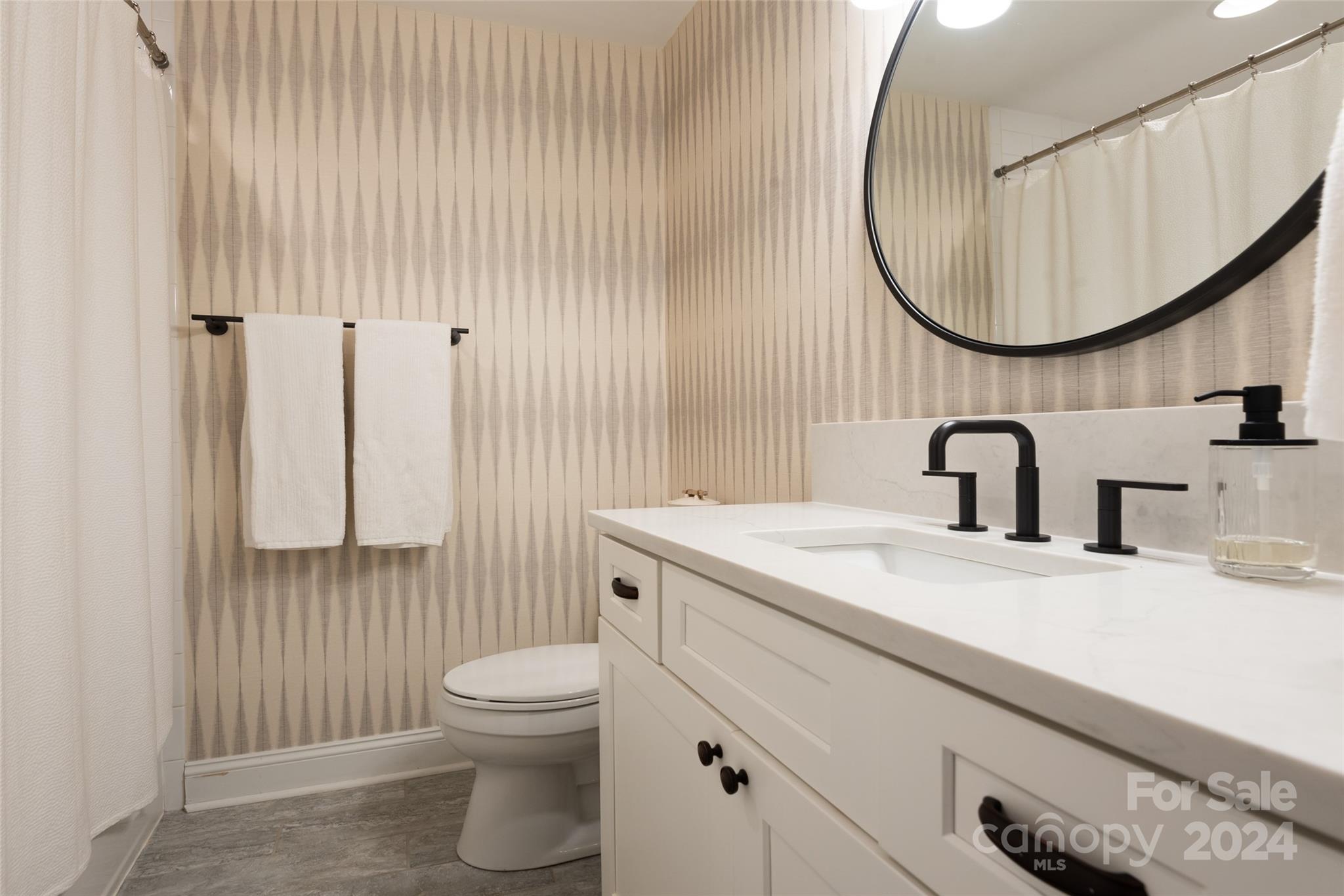 665 Marsh Road Charlotte, NC 28209 - Photo 16 of 31 a bathroom with a sink a toilet and a mirror
