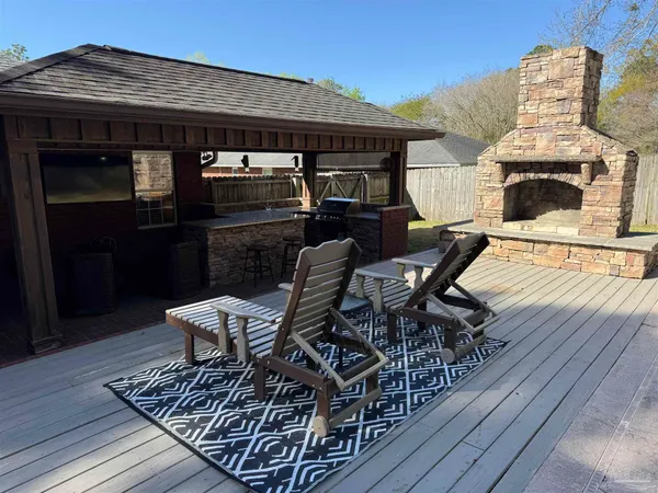 a view of a roof deck with table and chairs with wooden floor and fence