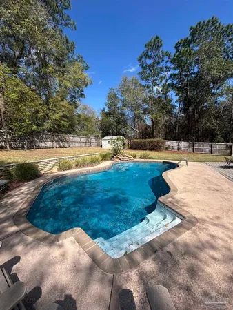 a view of a house with pool and a yard