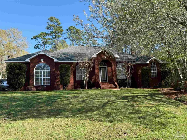 a view of a big house with a big yard and large trees
